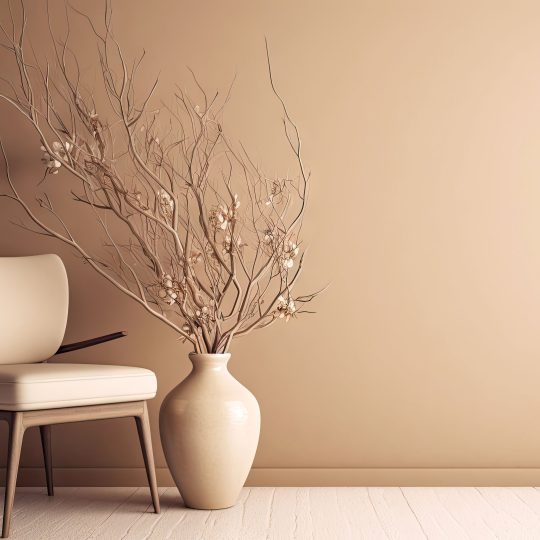 A modern chair and a vase kept in front of a matt-finish beige color wall.