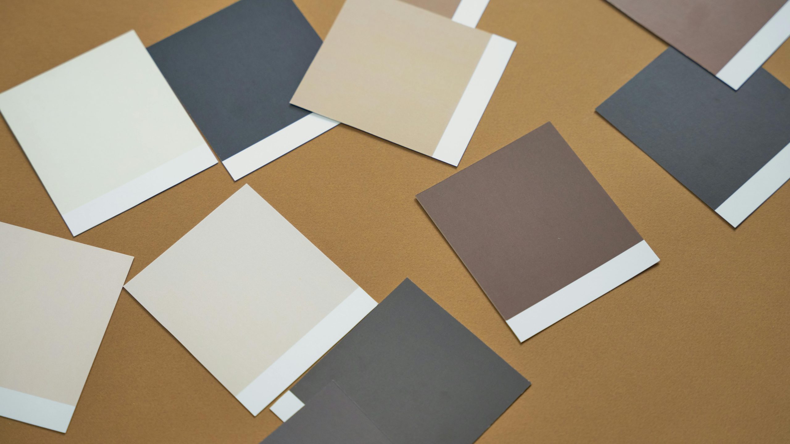 Pantone Colour of the Year 2025 Mocha Mousse shown with paint swatches in warm neutral tones on a brown background.