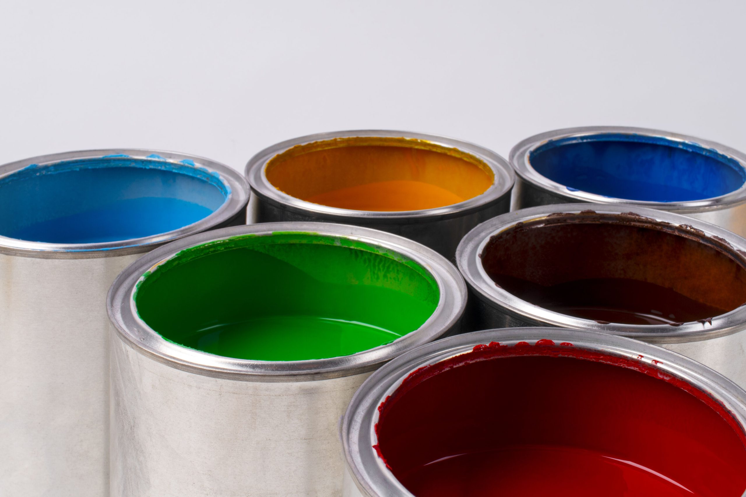 Open cans of colorful paint showcasing different paint options and finishes by Berger Paints.