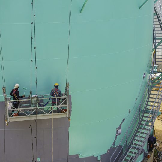 Workers applying protective coating systems on large offshore industrial structure in Singapore.