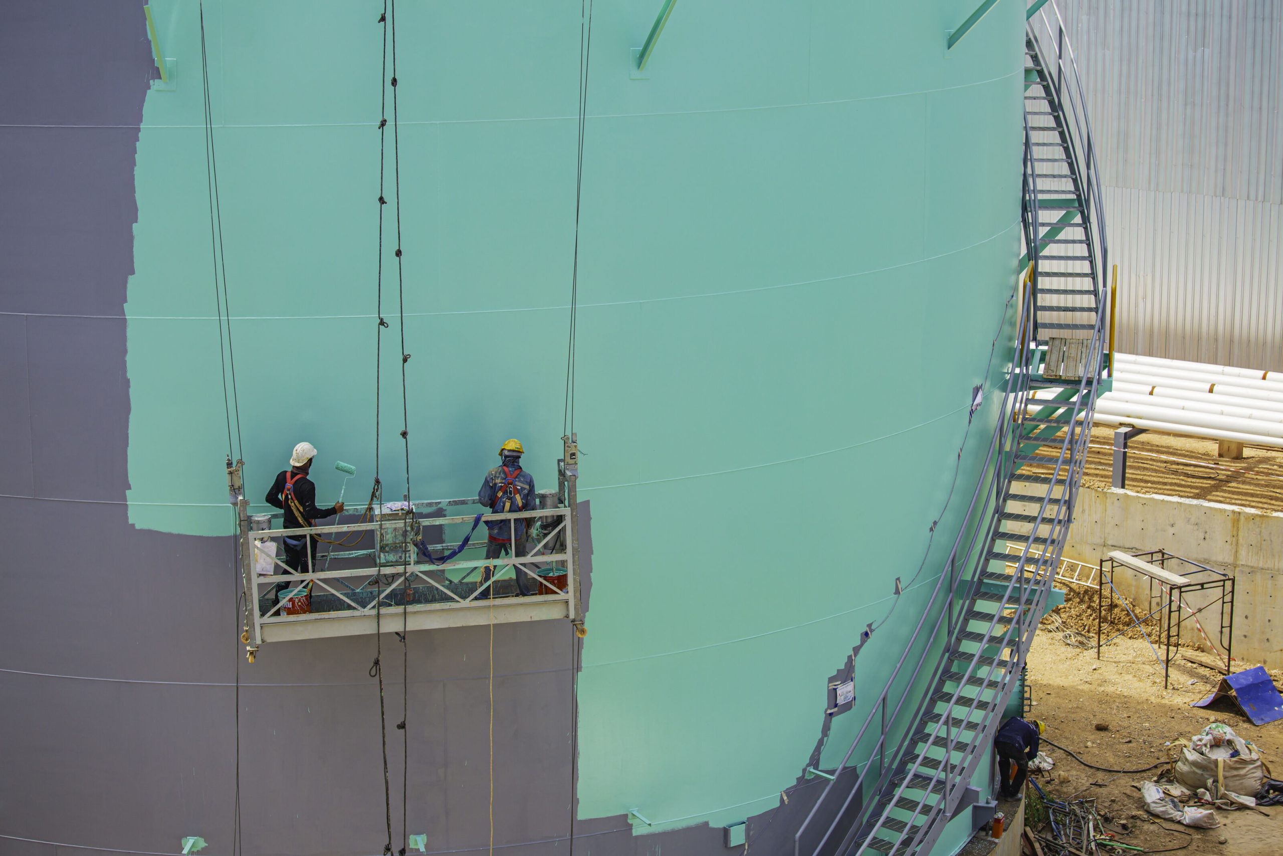 Workers applying protective coating systems on large offshore industrial structure in Singapore.