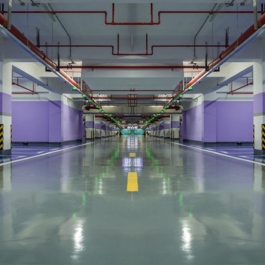 Glossy commercial floor coating in an underground parking area showing durable industrial flooring.